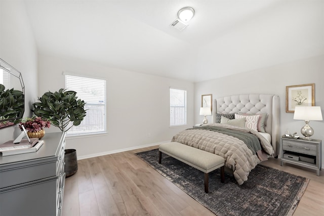 bedroom with vaulted ceiling and light hardwood / wood-style flooring