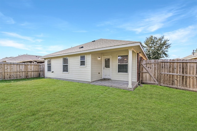 rear view of property featuring a yard and a patio area