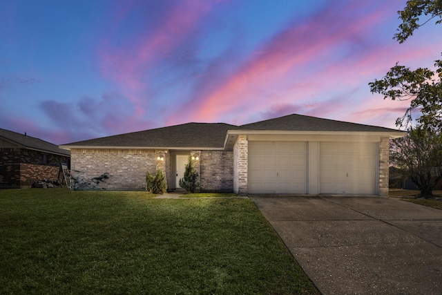 single story home featuring a garage and a lawn