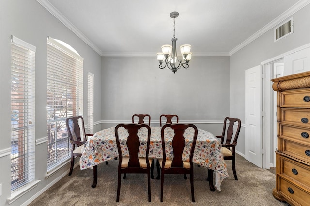 dining room with crown molding, carpet floors, and a chandelier