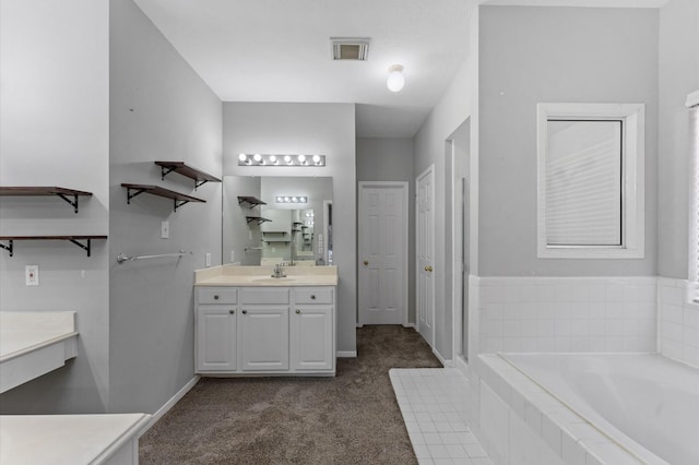 bathroom featuring vanity and tiled bath