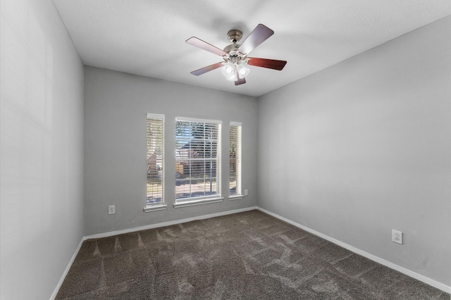 unfurnished room featuring dark carpet and ceiling fan