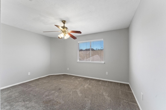 spare room with ceiling fan, dark carpet, and a textured ceiling