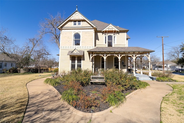 victorian home featuring a porch and a front yard