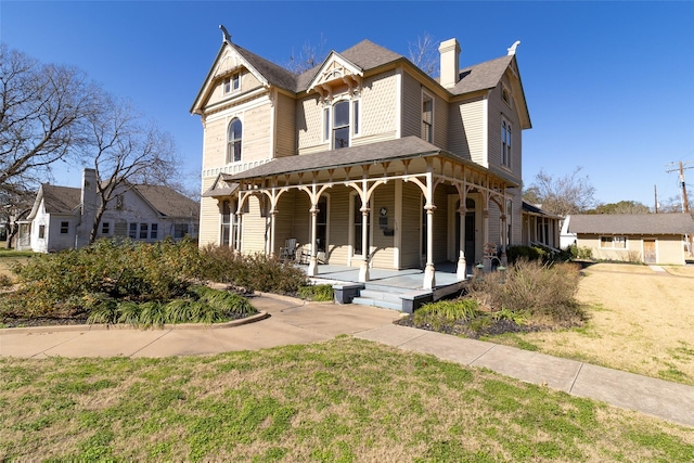 victorian house featuring a front lawn and covered porch