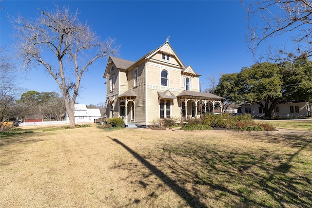 victorian home with a front lawn