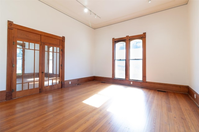 empty room featuring rail lighting and hardwood / wood-style floors