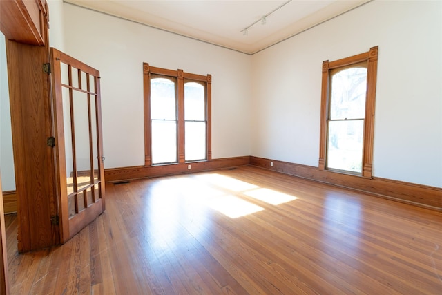 unfurnished room with wood-type flooring and track lighting