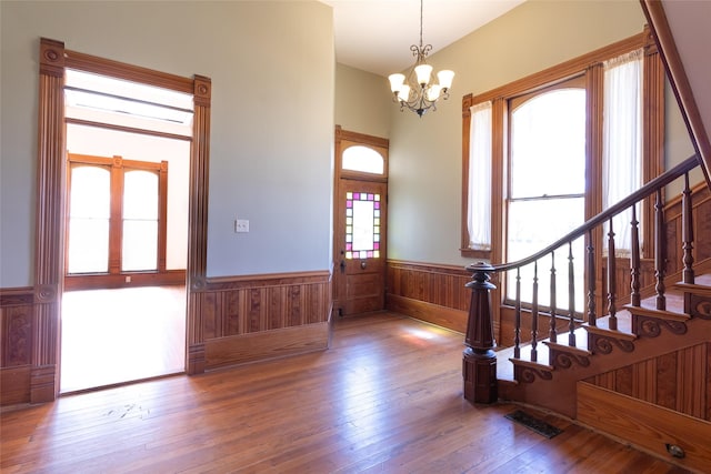 entrance foyer with an inviting chandelier and hardwood / wood-style floors