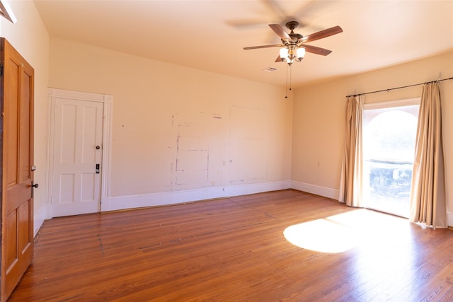 empty room with hardwood / wood-style floors and ceiling fan