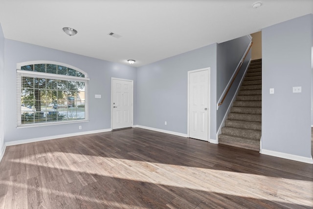 unfurnished living room with dark wood-type flooring