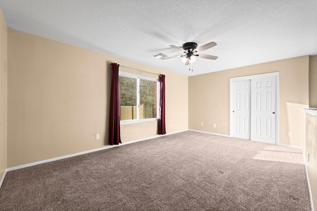 spare room featuring ceiling fan, carpet flooring, and a textured ceiling