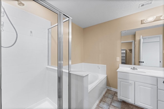 bathroom featuring vanity, a textured ceiling, and separate shower and tub