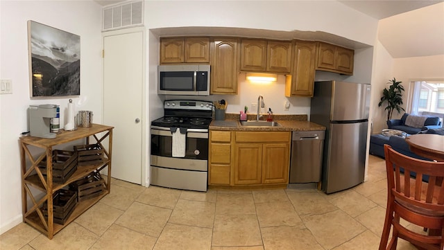 kitchen featuring appliances with stainless steel finishes, sink, and light tile patterned floors