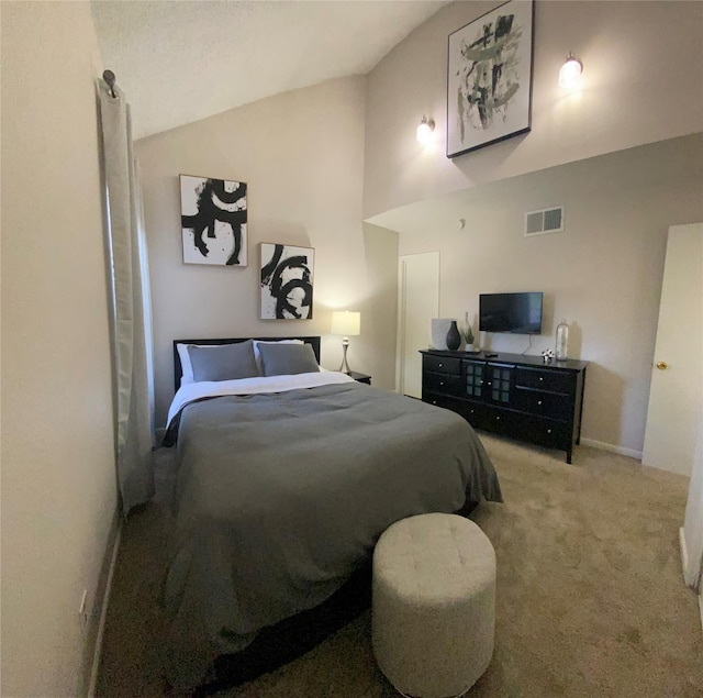 carpeted bedroom with high vaulted ceiling