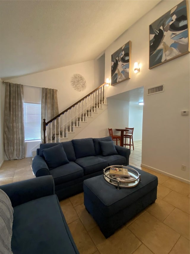 tiled living room with lofted ceiling and a textured ceiling