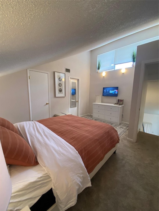 bedroom with lofted ceiling, carpet flooring, and a textured ceiling