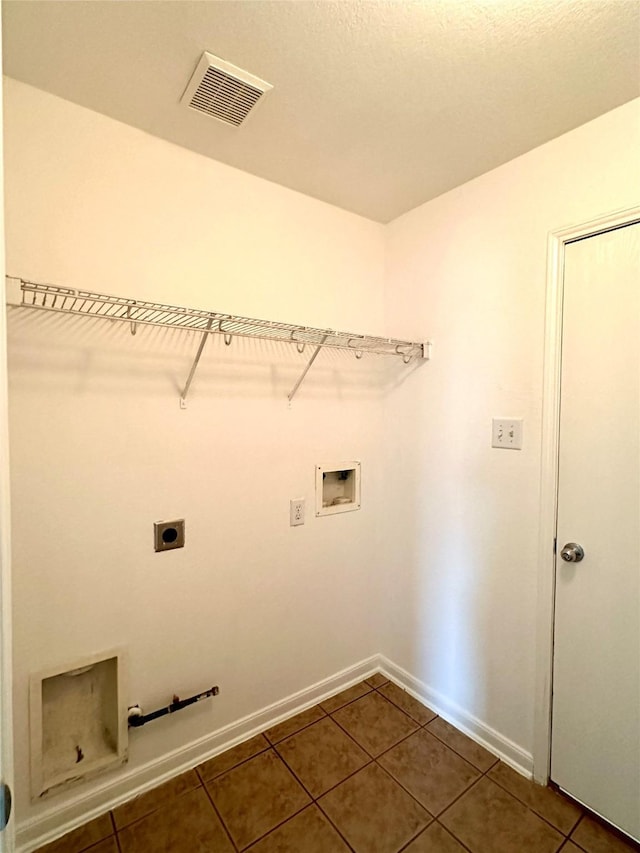 laundry area featuring washer hookup, electric dryer hookup, and dark tile patterned floors