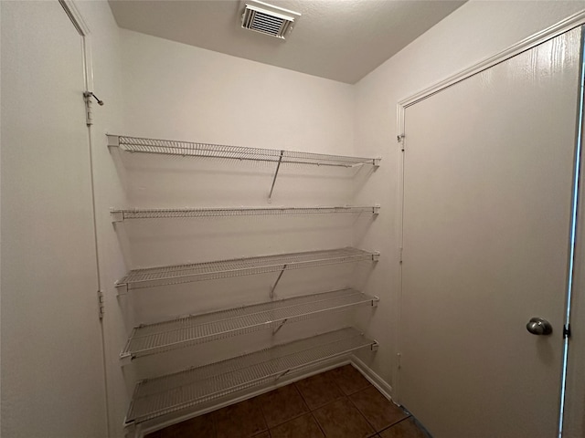 spacious closet with dark tile patterned floors