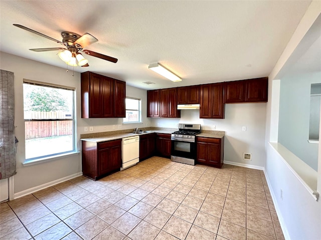 kitchen with dishwasher, sink, light tile patterned floors, gas stove, and a textured ceiling