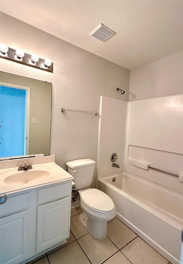 full bathroom with washtub / shower combination, toilet, a textured ceiling, vanity, and tile patterned flooring