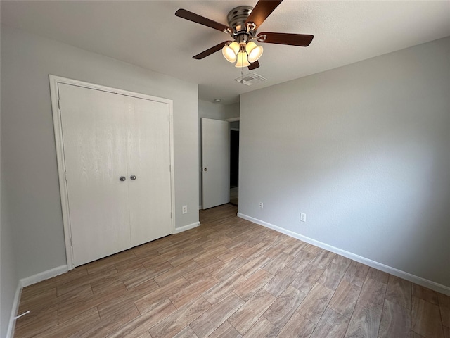 unfurnished bedroom with a closet, ceiling fan, and light wood-type flooring