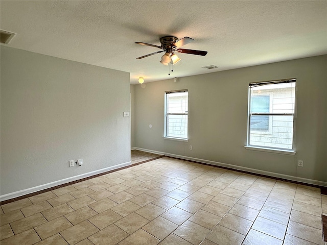 tiled empty room with a textured ceiling and ceiling fan