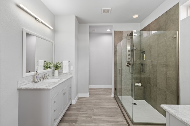 bathroom with vanity, an enclosed shower, and hardwood / wood-style floors