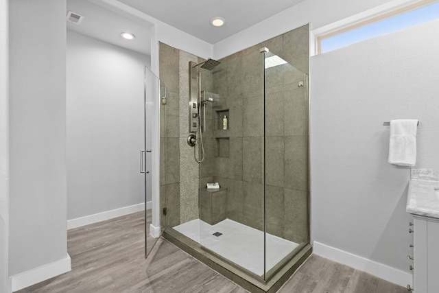 bathroom with vanity, hardwood / wood-style flooring, and a shower with door