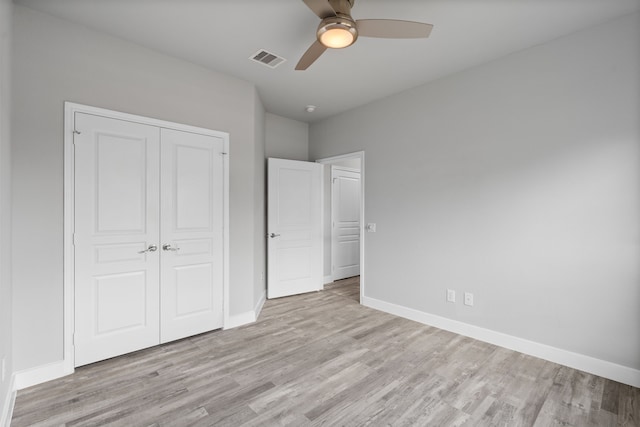 unfurnished bedroom featuring ceiling fan, a closet, and light hardwood / wood-style flooring