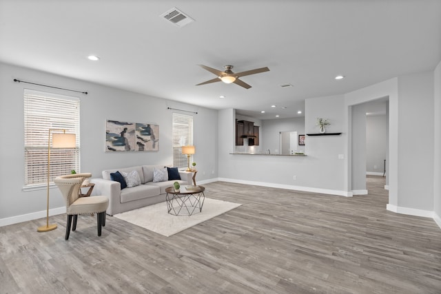 living room featuring ceiling fan and light wood-type flooring