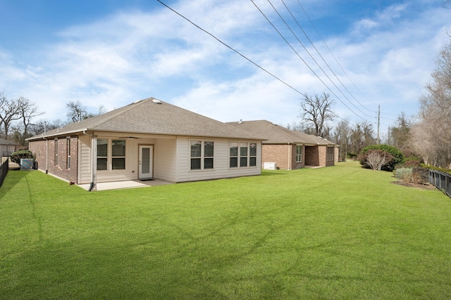 back of house featuring a lawn and a patio