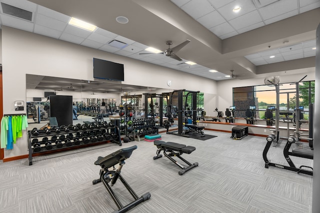 workout area with light carpet, ceiling fan, and a drop ceiling