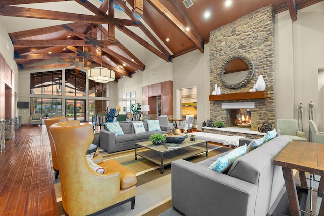 living room with beam ceiling, hardwood / wood-style flooring, a fireplace, and high vaulted ceiling