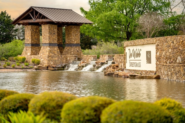 community / neighborhood sign with a water view