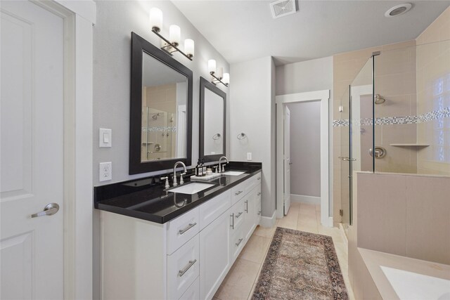 full bathroom featuring double vanity, tile patterned floors, a sink, and a shower stall