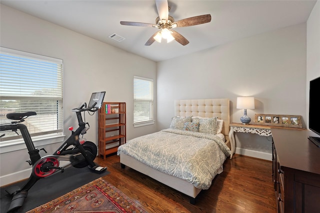 bedroom featuring ceiling fan, dark wood finished floors, visible vents, and baseboards