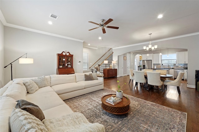 living room with ornamental molding, ceiling fan with notable chandelier, and hardwood / wood-style floors