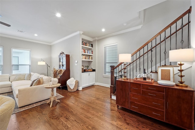 living area with visible vents, stairway, ornamental molding, wood finished floors, and built in shelves