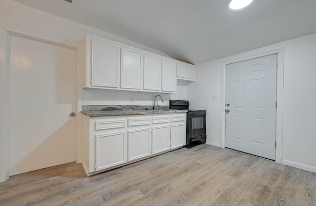 kitchen with sink, white cabinets, black range with electric cooktop, vaulted ceiling, and light wood-type flooring