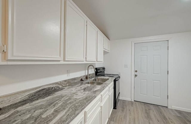 kitchen with sink, white cabinetry, light stone counters, black range with electric cooktop, and light wood-type flooring