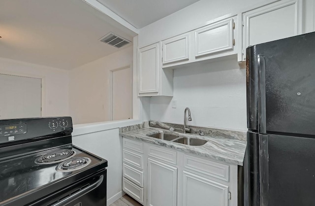 kitchen featuring white cabinetry, sink, light stone counters, and black appliances