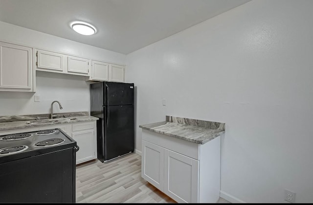 kitchen with white cabinetry, sink, light hardwood / wood-style floors, and black appliances