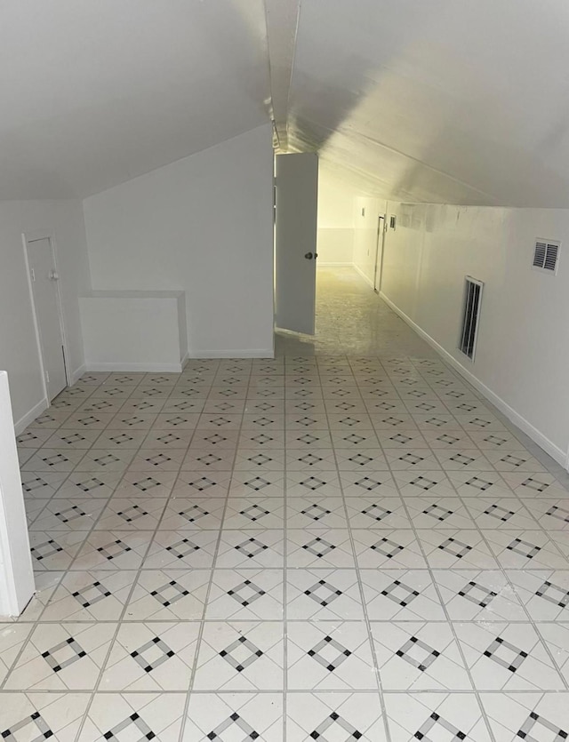 additional living space with lofted ceiling and light tile patterned floors