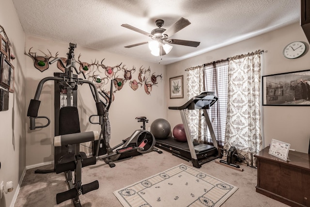 exercise area featuring ceiling fan, light colored carpet, and a textured ceiling