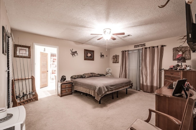 carpeted bedroom with ceiling fan, a textured ceiling, and visible vents