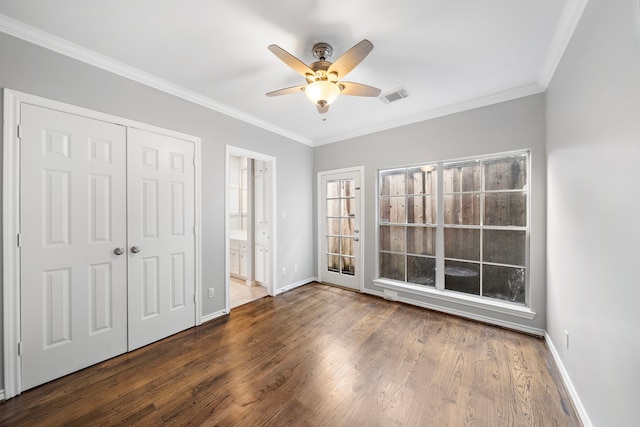 unfurnished bedroom featuring crown molding, ceiling fan, connected bathroom, dark hardwood / wood-style flooring, and a closet