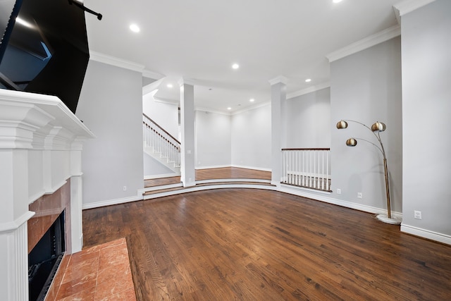 unfurnished living room featuring hardwood / wood-style flooring, ornamental molding, and a fireplace