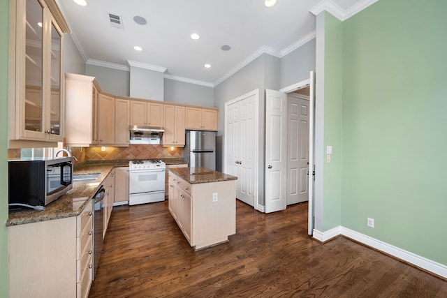 kitchen with tasteful backsplash, stainless steel appliances, a kitchen island, and dark stone counters