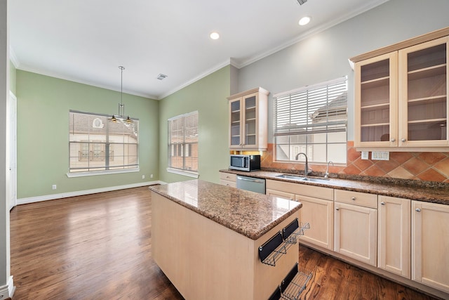 kitchen featuring pendant lighting, sink, appliances with stainless steel finishes, backsplash, and a kitchen island